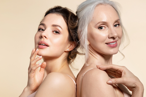 Two women with glowing, smooth skin standing back-to-back, representing the rejuvenating effects of IV Glutathione treatment.
